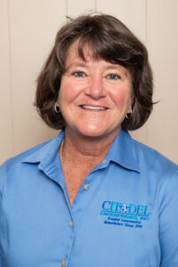 Liz Loy, Vice President of Citadel Enterprises, smiling in a blue company shirt with logo, showcasing expertise in home remodeling.