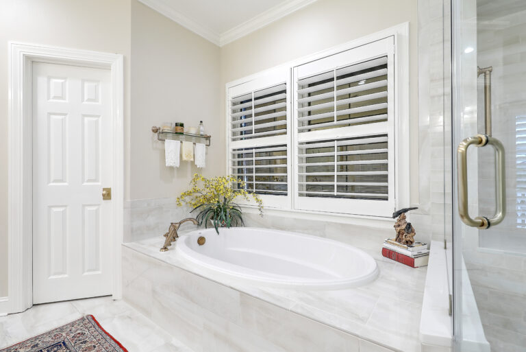 Remodeled Lowcountry bathroom with soaking tub and white plantation shutters
