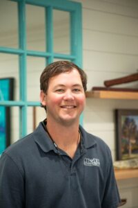 Home remodeling contractor smiling in a professional setting, showcasing expertise and approachability at Citadel Enterprises.